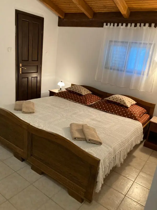 Une chambre lumineuse avec un grand lit recouvert d'une courtepointe.