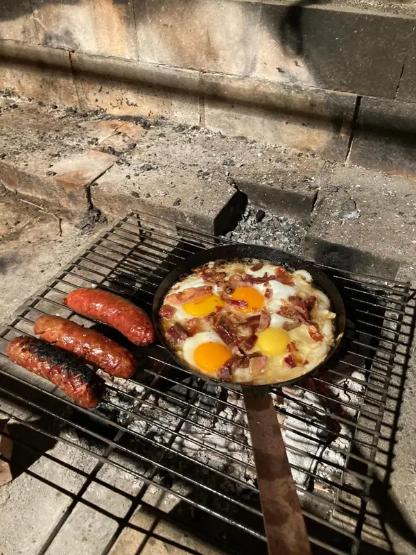 Petit-déjeuner copieux cuisiné sur un gril à charbon.