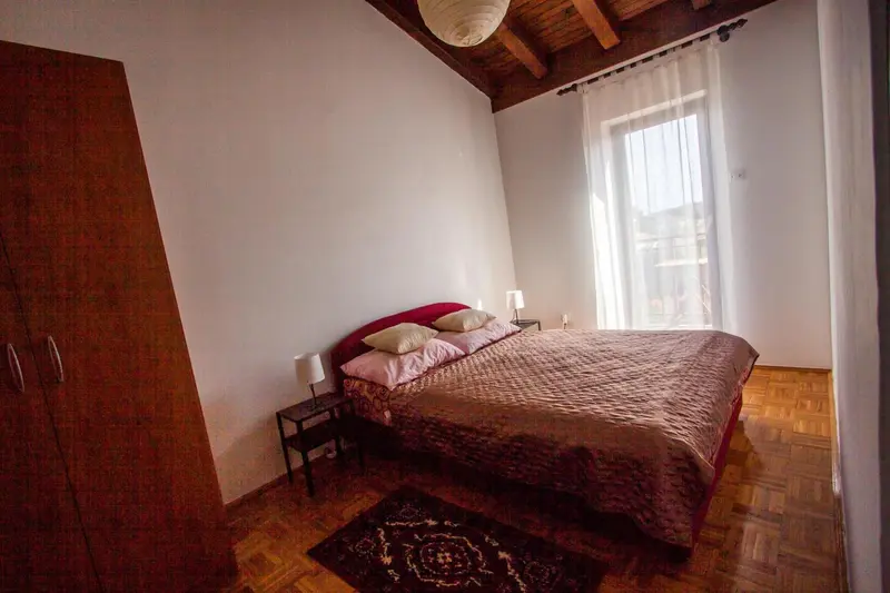 Une chambre avec un lit double et une armoire en bois.