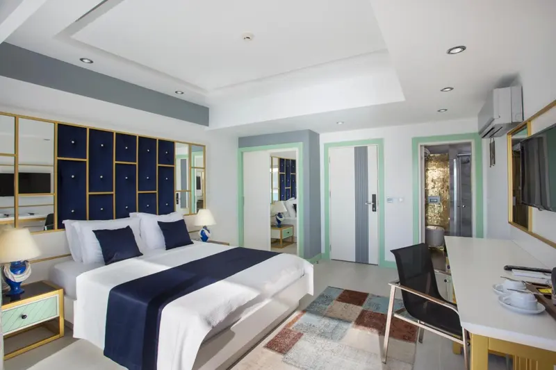Chambre moderne avec un grand lit et un espace bureau.