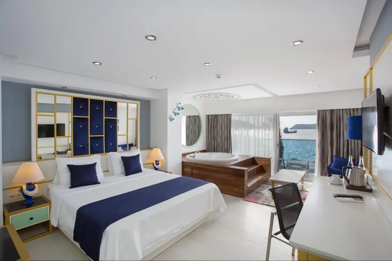 Une chambre lumineuse avec un grand lit et un jacuzzi.