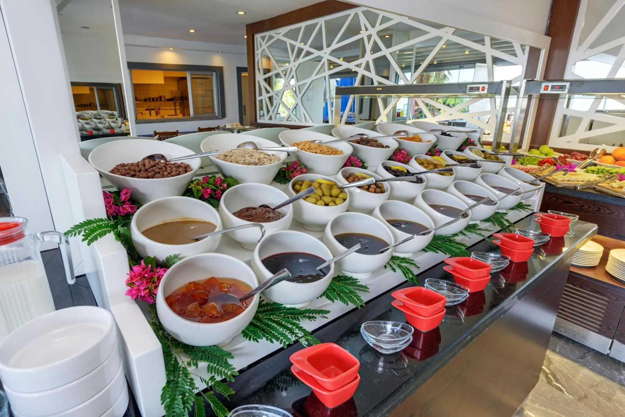 Un buffet propose une grande variété de céréales, de fruits et de condiments.