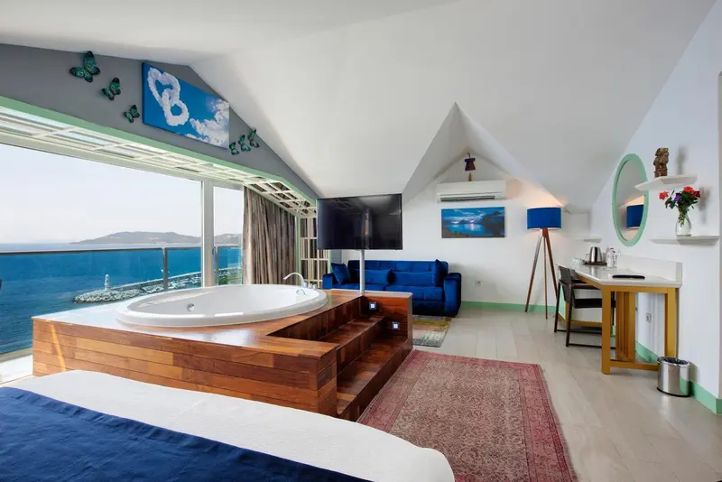 Une chambre spacieuse avec un jacuzzi et une vue sur la mer.