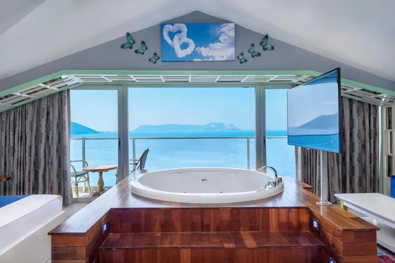 Une baignoire d'angle offre une vue dégagée sur la mer.