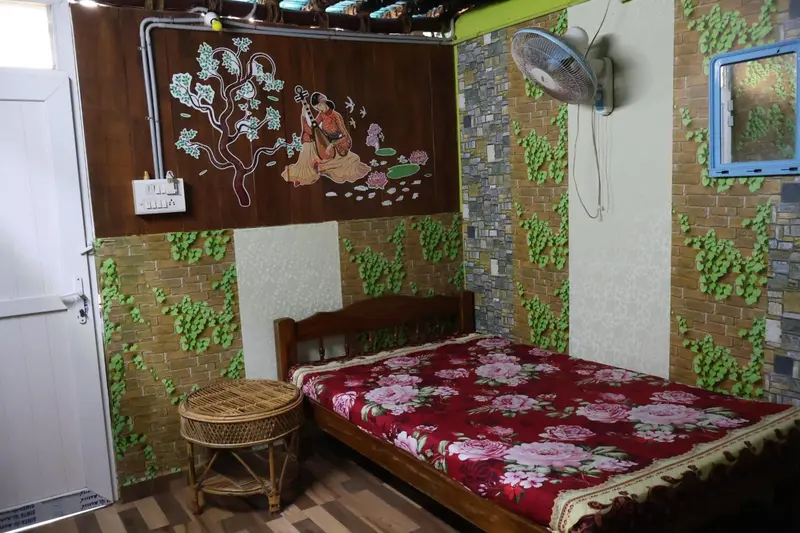 Une chambre décorée avec un lit et un mur orné d'une peinture florale.