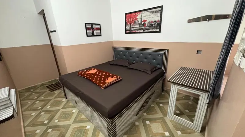 Une chambre avec un lit recouvert d'une couverture et deux tables de chevet.