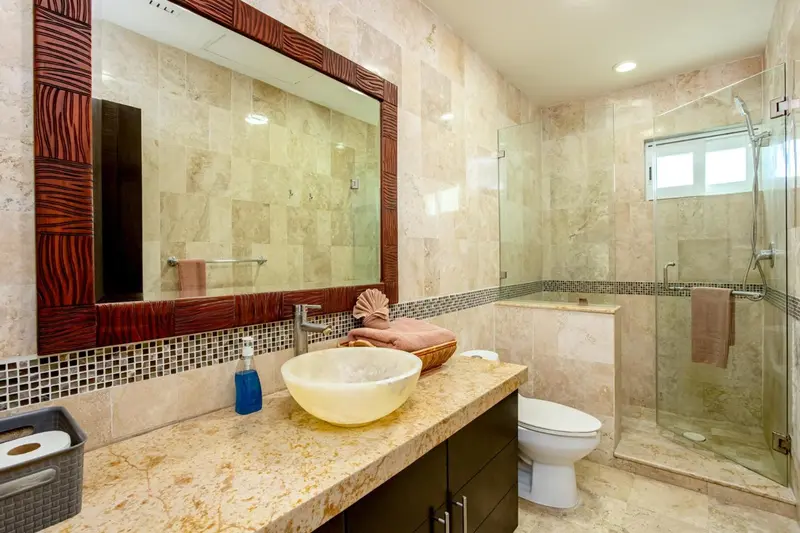 Une salle de bain lumineuse avec douche à l'italienne et vasque sur plan de travail.