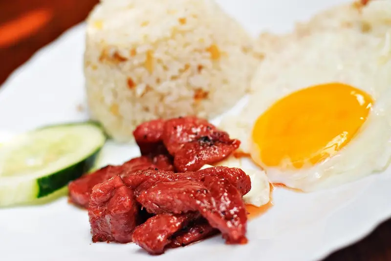 Assiette de riz, d'œuf au plat, de saucisse et de concombre.