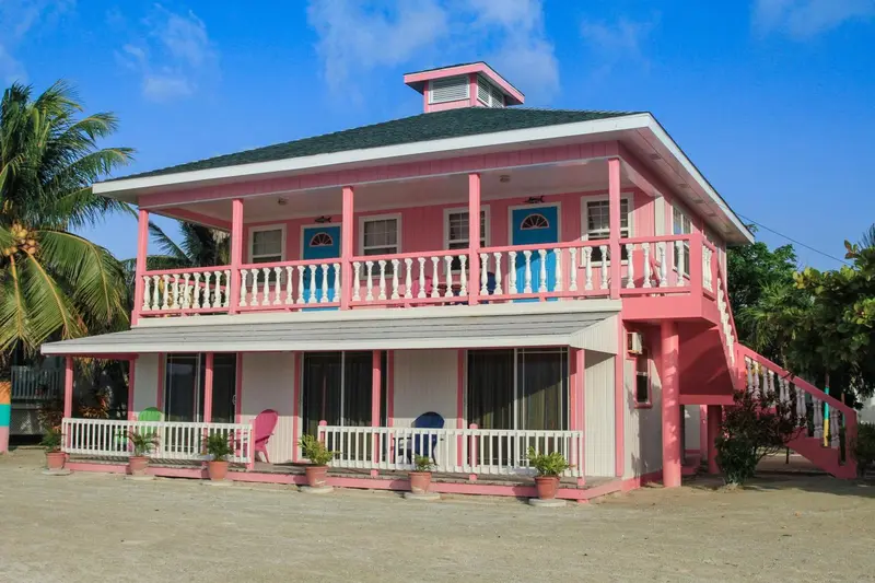 Bâtiment rose à deux étages avec des balcons et des fenêtres.