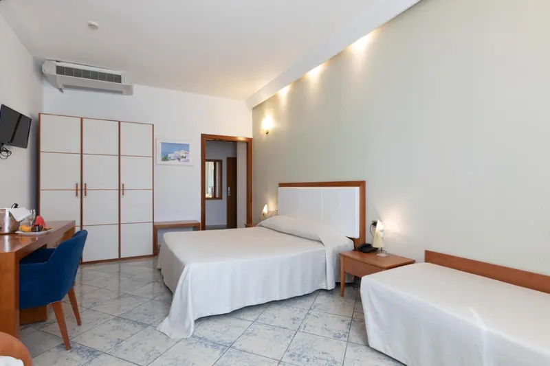 Chambre lumineuse avec un lit double et un bureau.