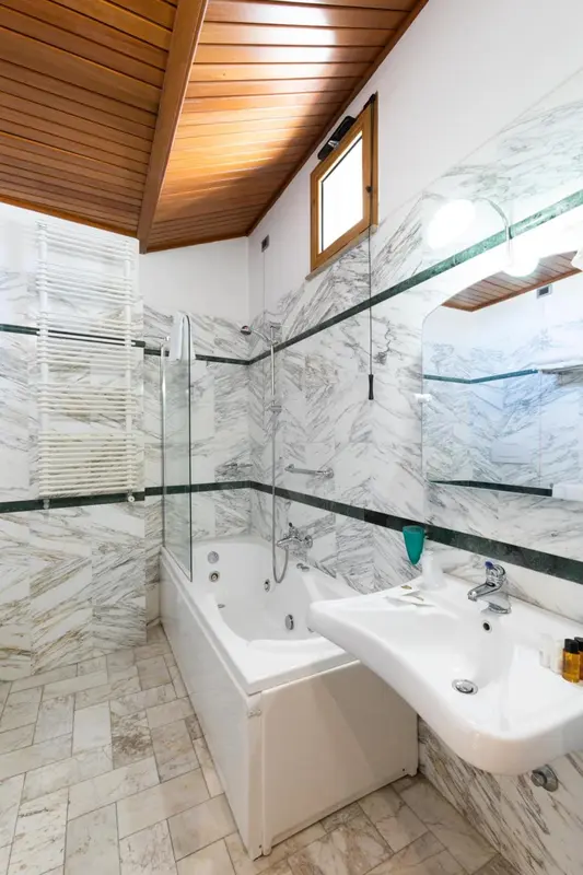 Une salle de bain lumineuse avec baignoire et douche à l'italienne.