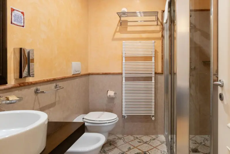 Une salle de bain avec douche, lavabo et toilette.