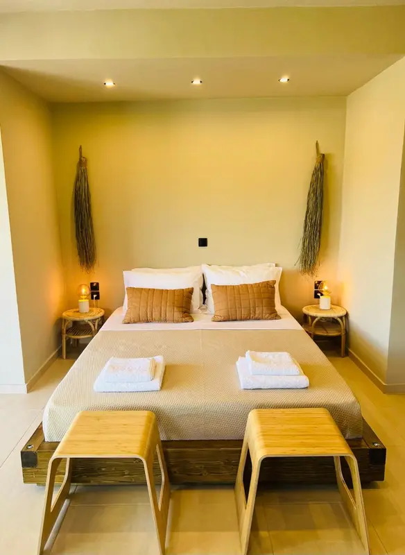 Une chambre lumineuse avec un grand lit et des éléments décoratifs en fibres naturelles.