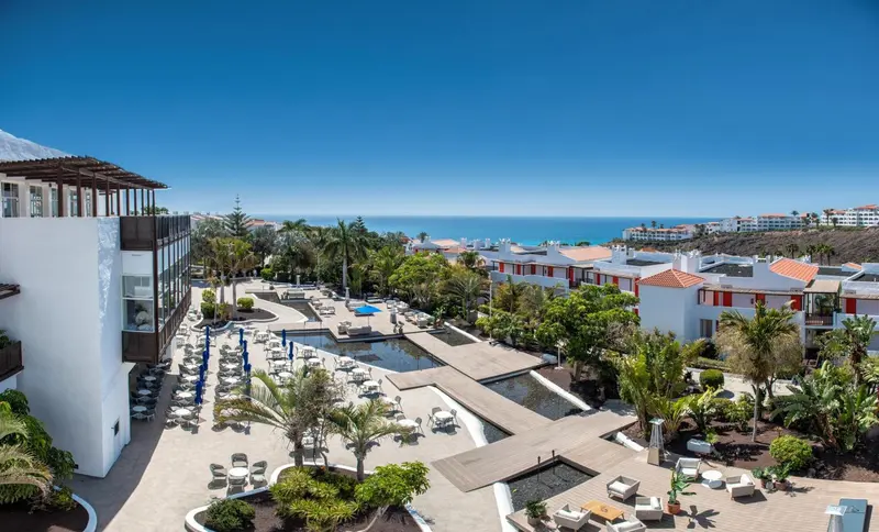 Vue aérienne d'un complexe hôtelier avec piscine et végétation luxuriante.