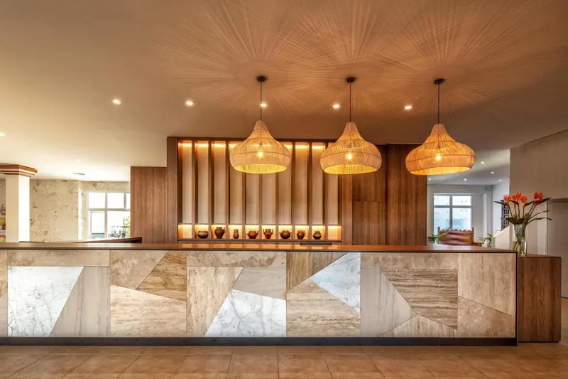 Un comptoir d'accueil moderne avec un éclairage suspendu décoratif.