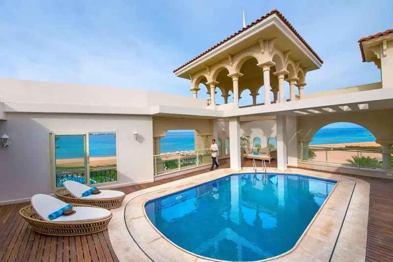 Terrasse avec piscine et mobilier de détente.