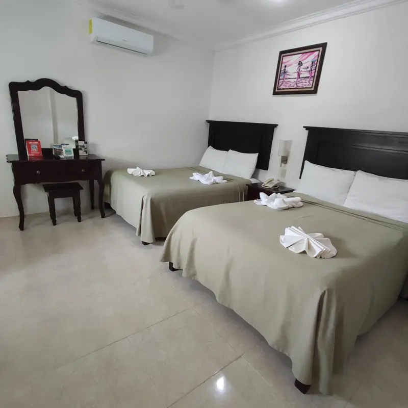 Une chambre avec deux lits et une coiffeuse.