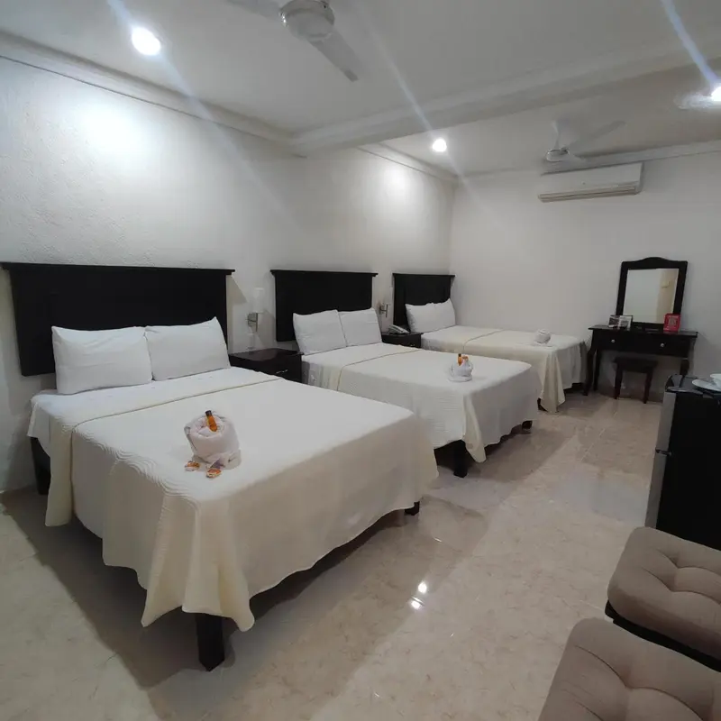 Une chambre lumineuse avec deux lits simples et un coin repos.
