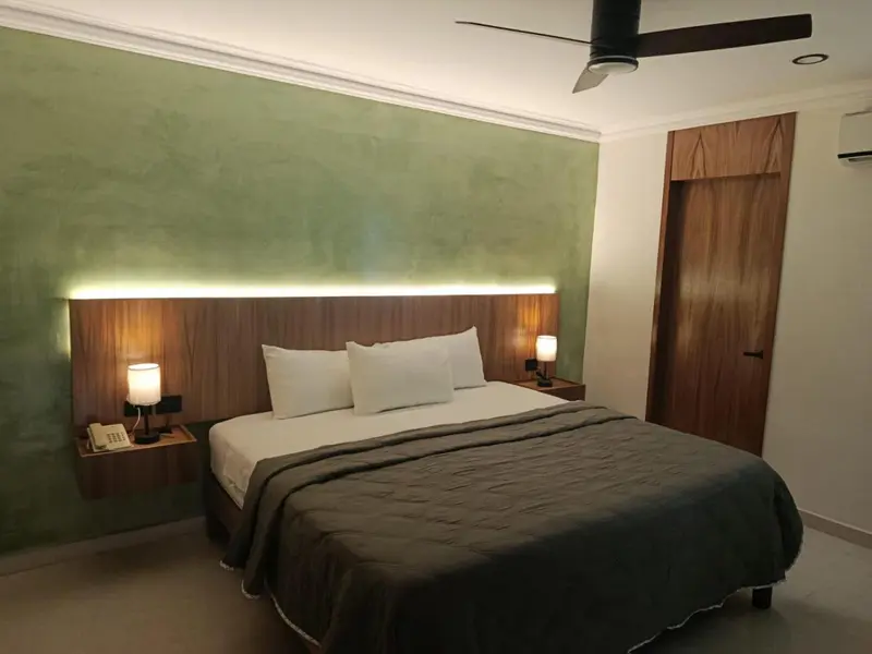 Une chambre lumineuse avec un grand lit et une décoration sobre.