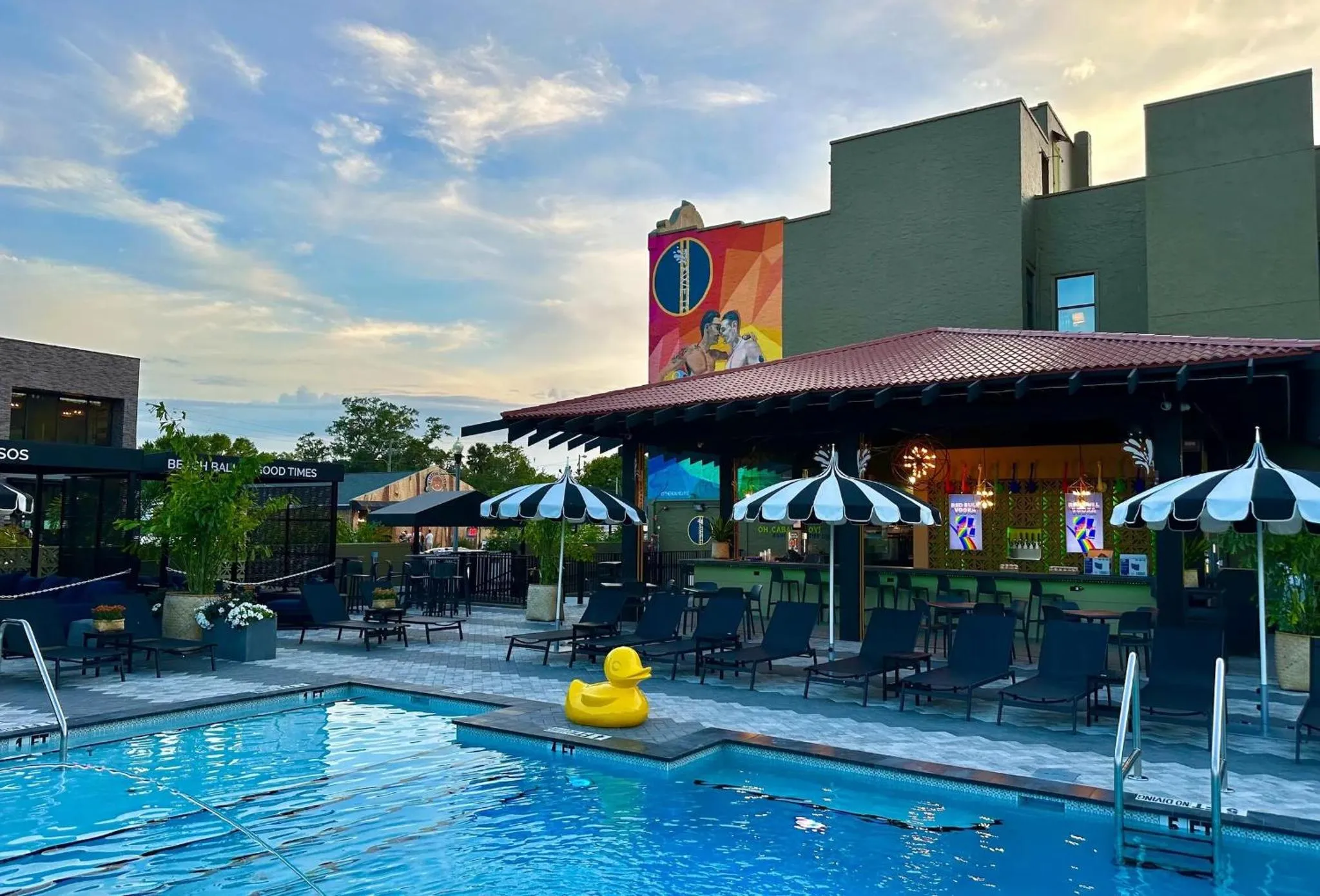 Terrasse avec bar et piscine au bord d'un bâtiment.