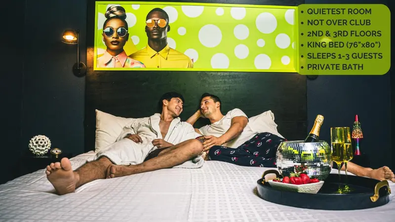 Un couple se détend sur un grand lit dans une chambre d'hôtel décorée de manière originale.