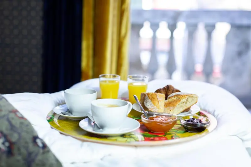 Un petit-déjeuner est servi sur un plateau en lit.