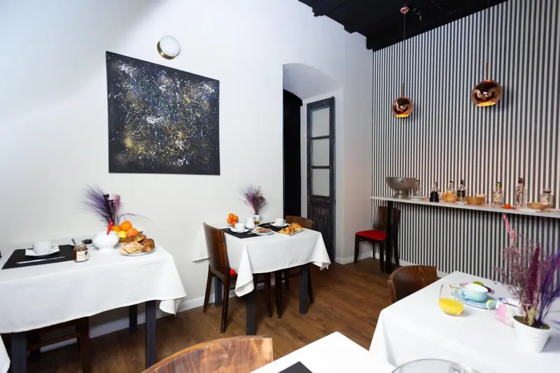 Une table est dressée pour le petit-déjeuner dans une salle lumineuse.