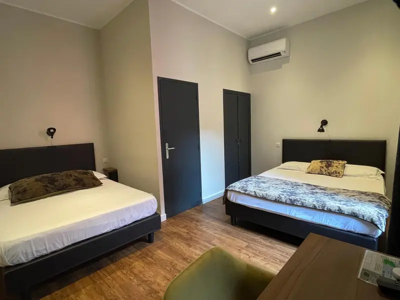 Une chambre avec deux lits simples et une décoration sobre.