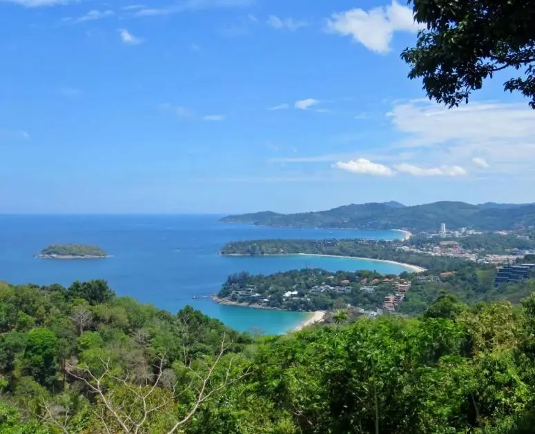 Vue panoramique sur une baie bordée de végétation et de bâtiments.