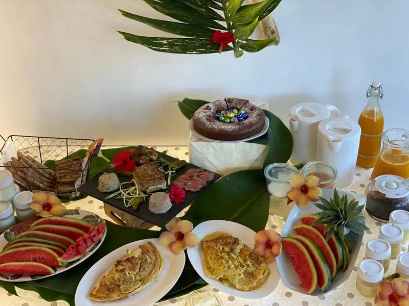 Table garnie de mets variés et de fruits frais.