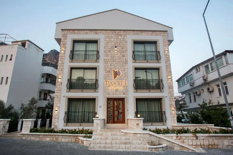 Façade d'un bâtiment blanc à deux étages avec des balcons et une entrée décorée.