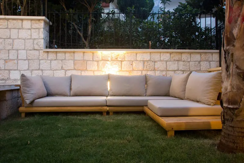 Canapé d'extérieur confortable sur une pelouse verdoyante.
