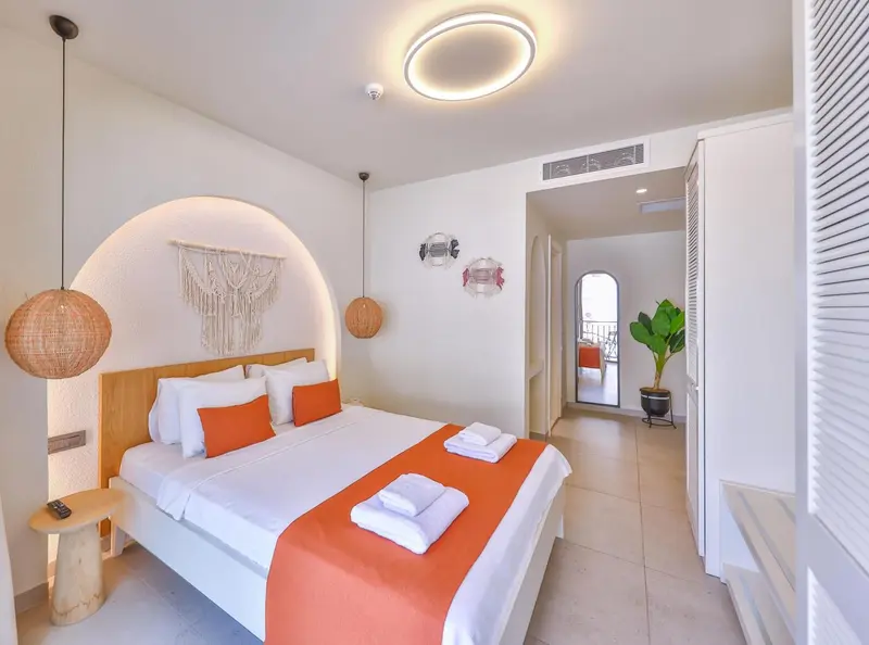 Chambre lumineuse avec un grand lit et une décoration murale.