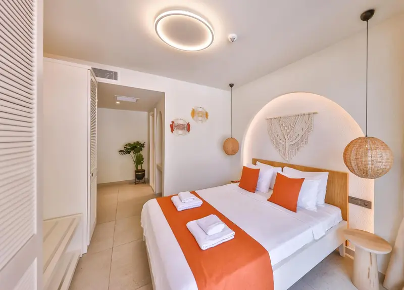 Une chambre lumineuse avec un grand lit et une décoration murale.