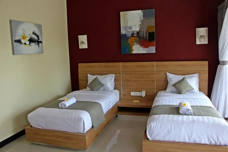 Une chambre avec deux lits simples et une décoration murale.
