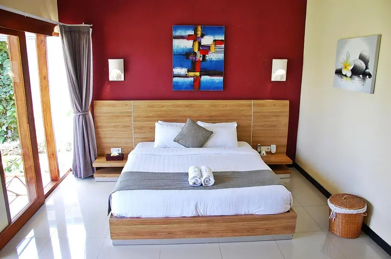 Une chambre lumineuse avec un grand lit et une décoration murale.