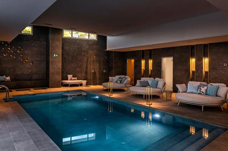 Espace de détente intérieur avec piscine et mobilier confortable.