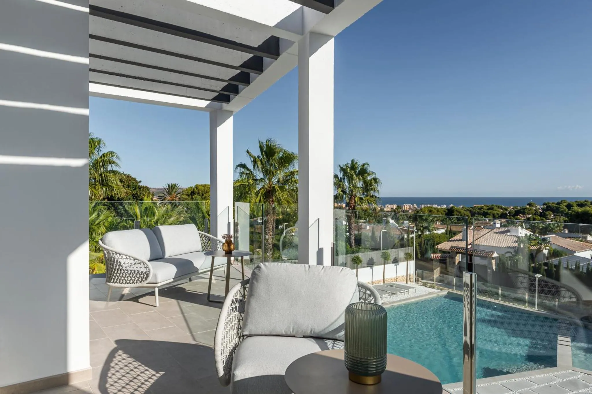 Terrasse aménagée avec salon et vue sur la mer et la piscine.