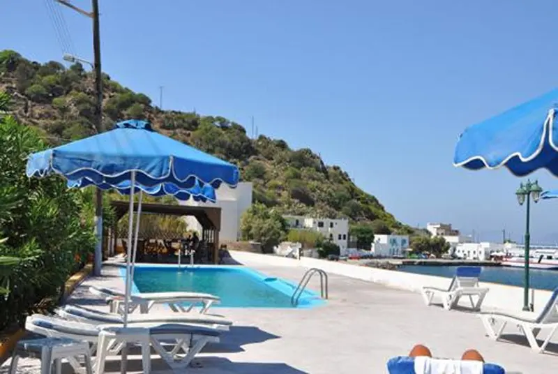 Transats bleus et parasols au bord d'une piscine ensoleillée.