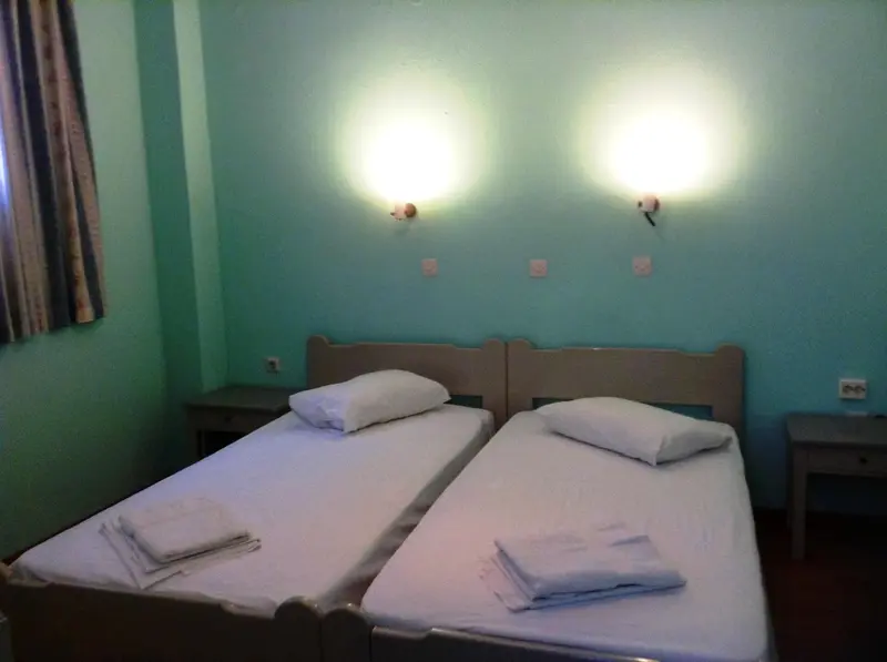 Une chambre avec deux lits simples et des tables de chevet.