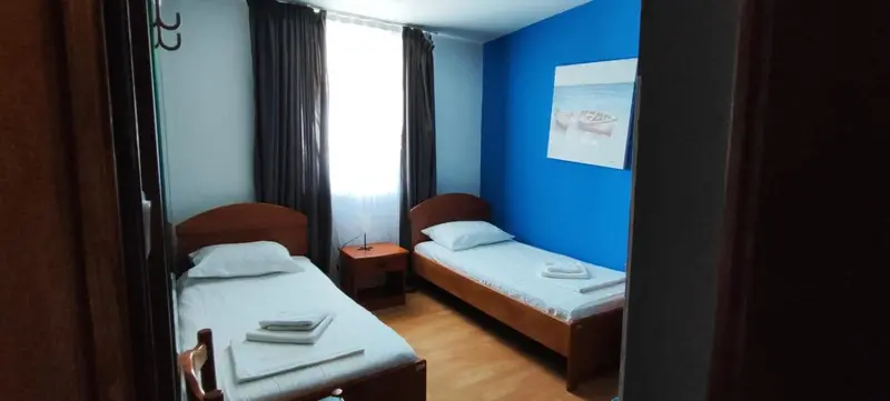 Une chambre avec deux lits simples et une décoration sobre.