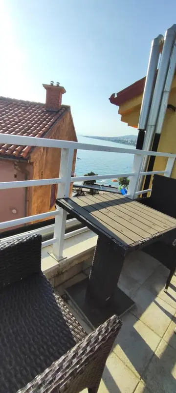 Terrasse en bois avec mobilier d'extérieur donnant sur la mer.