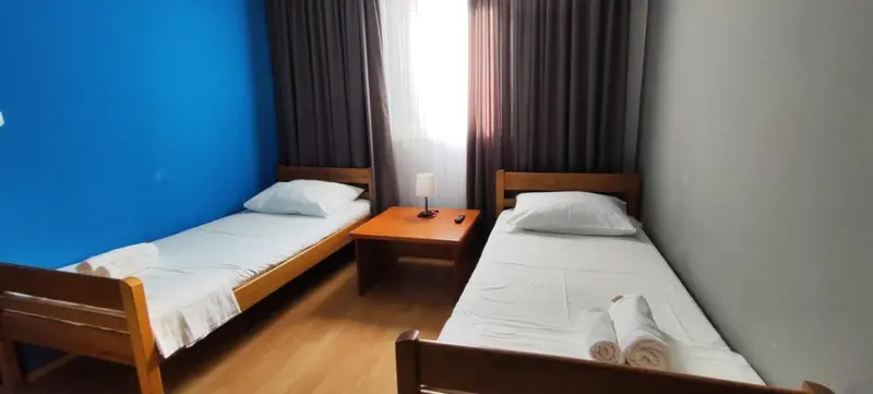 Deux lits simples dans une chambre lumineuse.