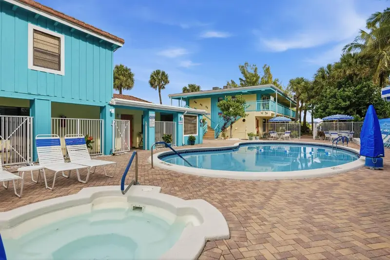 Bâtiments colorés entourant une piscine et un jacuzzi en extérieur.