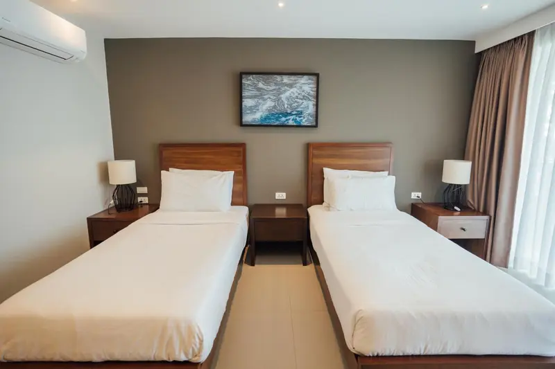 Une chambre avec deux lits simples et des tables de chevet.