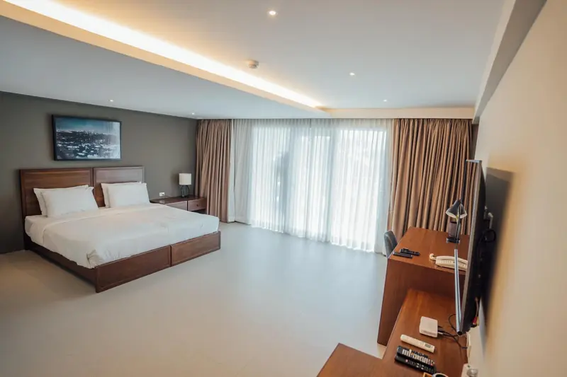Une chambre lumineuse avec un grand lit et un espace bureau.
