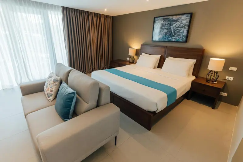 Une chambre lumineuse avec un grand lit et un coin salon.