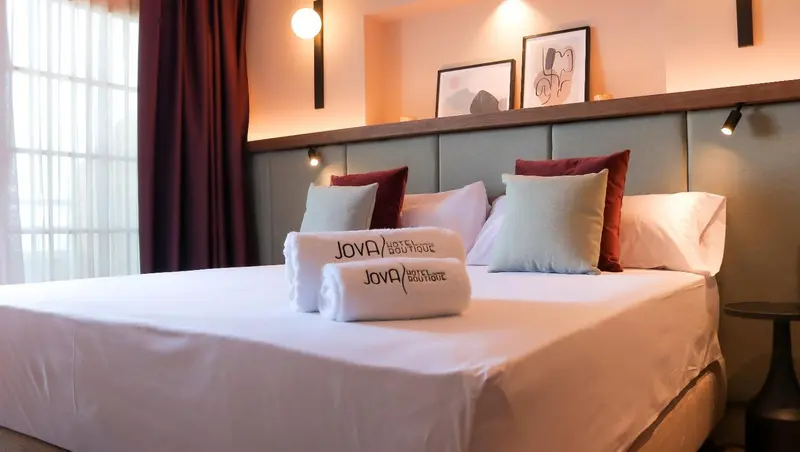 Lit préparé avec des oreillers et des serviettes dans une chambre d'hôtel.