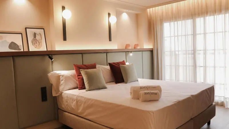 Lit double avec oreillers et couvertures blanches dans une chambre lumineuse.
