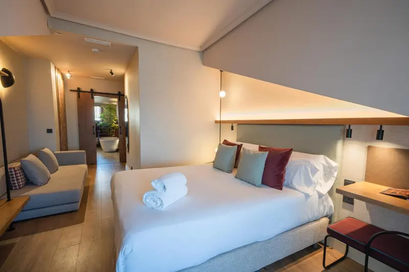 Une chambre lumineuse avec un lit et un canapé.